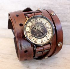 ✅CUCKOO NEST ART STUDIO DESIGN Men's leather watch made with veg tanned leather, completely handmade. The leather cuff is 2 1/2 inches wide. Item includes a vintage style Cuckoo Nest Art Studio™ watch face and is removable and interchangeable. Heavy duty buckle provides closure. ✅THIS WATCH IS MADE TO ORDER, please use the following measuring technique to determine your wrist size: MEASURE YOUR WRIST over and around the wrist bone using a measuring tape, do not add to it. You want to measure is Vintage Leather Watch With Bracelet Strap, Vintage Brown Watches With Leather Strap, Vintage Brown Watch With Leather Strap, Vintage Brown Leather Bracelet As A Gift, Vintage Brown Leather Bracelet As Gift, Vintage Brown Leather Strap Bracelet As Gift, Vintage Leather Watches For Gift, Vintage Leather Watches As A Gift, Vintage Leather Watches As Gift