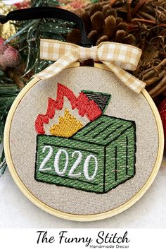 a cross stitch ornament with a campfire and the number 20 on it