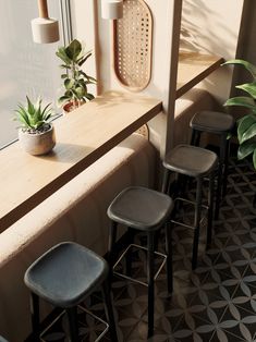 four stools are lined up in front of a window with potted plants on the ledge