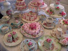 a table topped with lots of cakes and cupcakes