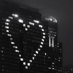 the building is lit up at night with lights on it's sides and windows