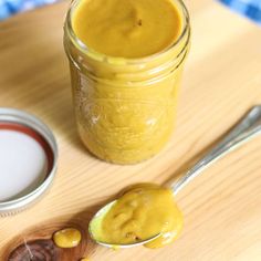 there is a jar of mustard next to a spoon