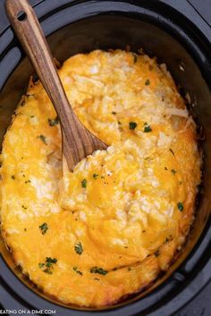 an omelet is being cooked in the crock pot with a wooden spoon