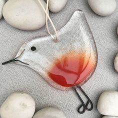 a glass bird ornament sitting on top of white rocks