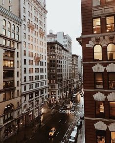 a city street filled with lots of traffic next to tall buildings and windows at night