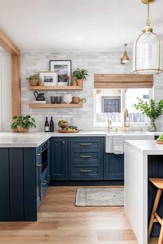 a kitchen with blue cabinets and white counter tops, wooden shelves and hanging plants on the wall