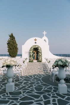 an outdoor wedding setup with white chairs and flowers