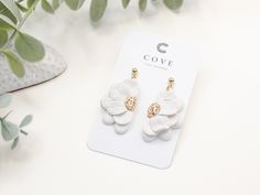 COVE Clay Designs  🌱 Flourish Collection - No.12 Handcrafted white flower clay earrings with 24k gold plated findings. Dainty and elegant floral earrings with handcrafted petal details, perfect for your beach and summer outfits or for a beautiful bride. The Flourish Collection is a beautiful floral/botanical collection representing the beauty of personal growth. When we are committed to -and invest time - in becoming the best version of ourselves, we blossom and grow into something really speci White Clip-on Earrings With Ear Wire For Wedding, White Clip-on Earrings For Wedding, White Flower-shaped Cluster Earrings For Gifts, Elegant 3d Flowers Adjustable Earrings, White Cluster Flower-shaped Earrings, Adjustable White Handmade Flowers Earrings, Gold Daisy Earrings, Flower Clay Earrings, White Flower Earrings