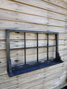 an old window on the side of a wooden building that is being used as a wall shelf