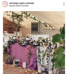 the table is set up with white and pink flowers, greenery, and vases