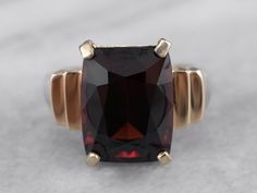 This beautifully structured vintage mounting holds a bold stone! This gem is a gorgeous deep red garnet, weighing in at nearly 10 carats. Garnets are known for their exceptional color and play of light, and this gem is opulent and sophisticated. Metal: 10K Yellow Gold Gem: Garnet 9.88 Carats Gem Measurements: 10.5 x 13.4 mm, Rectangle Cushion Cut Ring Size: 6.25 Marks: "10K" Stamped on the inside band Timeless Ruby Ring With Polished Finish For Formal Occasions, Formal Garnet Burgundy Ring, Formal Burgundy Garnet Ring, Formal Garnet Ring With Polished Finish, Elegant Polished Ruby Ring For Formal Occasions, Elegant Formal Ruby Ring With Polished Finish, Luxury Solitaire Ruby Ring For Formal Occasions, Luxury Solitaire Ruby Ring For Formal Events, Classic Garnet Jewelry With Polished Finish