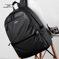 a surfboard sitting on top of a black backpack