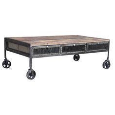 an industrial style coffee table with two drawers on casteors and wheels, against a white background