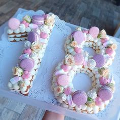 a cake shaped like the number 80 with flowers and seashells on it is being held by a woman