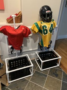 two football uniforms are hanging on the wall