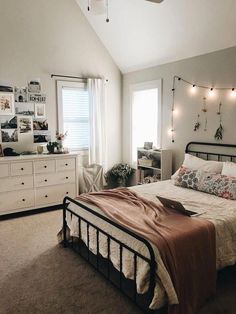 a bed room with a neatly made bed and lots of lights on the wall above it