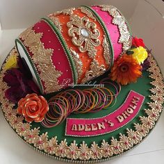 a cake decorated with ribbons and flowers in a box