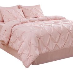 a bed with pink comforter and pillows on it