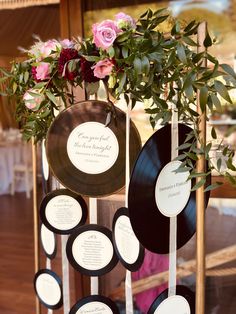 there are many records on the stand with flowers in them and some writing on them