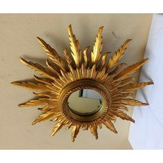 a gold sunburst mirror hanging on the wall