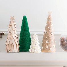 three wooden christmas trees sitting on top of a mantle