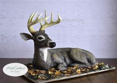 a deer statue sitting on top of a wooden table