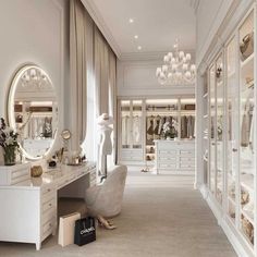 a white dressing room with chandelier and mirror