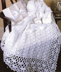 a white crocheted blanket sitting on top of a chair