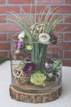 a glass vase filled with flowers on top of a table