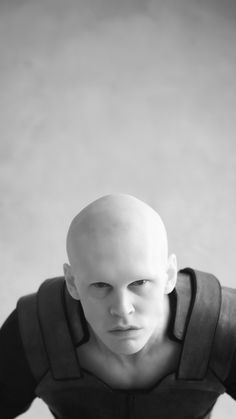 a bald man in black and white poses for the camera