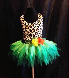 a leopard print top and green tutu skirt with orange flowers on a mannequin