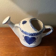 a ceramic teapot with blue hearts on it