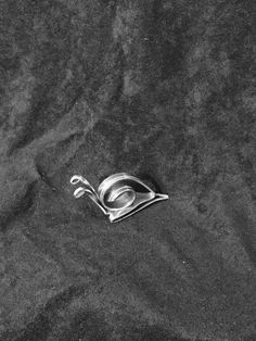 a metal object laying on top of a black surface next to a pair of scissors