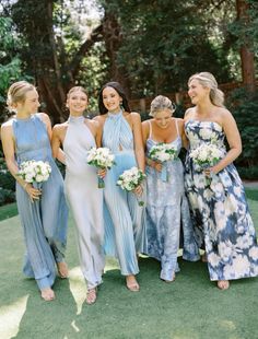 a group of women standing next to each other on top of a lush green field