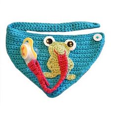 a blue crocheted bib with a frog on it's side and a fish in its mouth