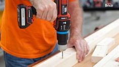 a man is using a drill to attach wood planks on a workbench