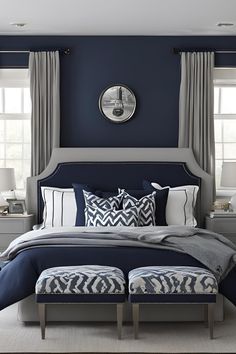 a bedroom with blue walls, white and gray bedding and two lamps on either side of the bed