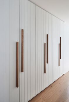 a room with white walls and wood trimmings on the wall, along with wooden flooring