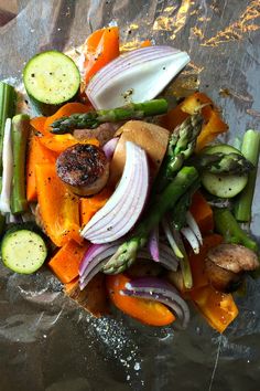 a pile of vegetables sitting on top of a metal pan filled with meat and veggies