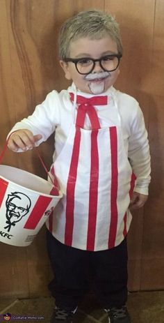 a little boy dressed up as a movie character holding a bucket and wearing eyeglasses