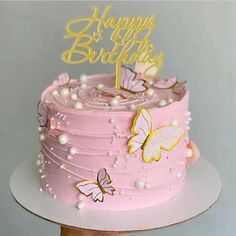 a pink birthday cake with butterflies on it