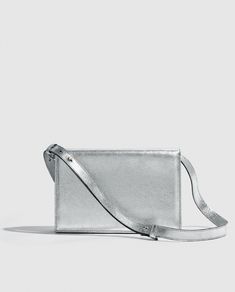 Silver metallic party bag with structured design, light and versatile. Vintage inspired.      

Made in bovine leather with metallic finish. 
Flap with magnetic clip closure.     
Adjustable and detachable long leather handle.
Open inside pocket. 
Designed and manufactured entirely in Spain using sustainable processes and small productions.
W17 cm x L25cm x D6 cm. Modern Silver Shoulder Bag For Formal Events, Modern Silver Bags For Formal Occasions, Metallic Rectangular Shoulder Bag With Removable Pouch, Classic Silver Rectangular Shoulder Bag, Silver Leather Clutch Evening Bag, Luxury Metallic Silver Shoulder Bag For Evening, Silver Clutch With Detachable Strap For Everyday Use, Metallic Clutch Bag For Formal Occasions, Silver Leather Evening Bag For Formal Occasions