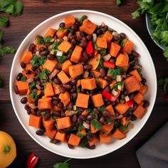 a white bowl filled with black beans and veggies on top of a wooden table