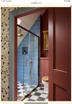 an open door leading to a bathroom with blue tiles on the walls and flooring