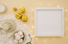 a white frame sitting on top of a doily next to some gold wrapped presents