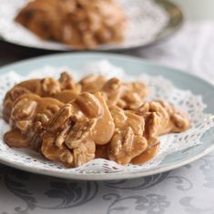 a plate full of cookies covered in caramel sauce on top of a doily