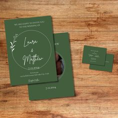 the wedding stationery is set on top of a wooden table with two envelopes