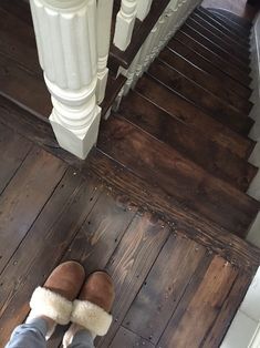 someone wearing slippers standing at the bottom of stairs