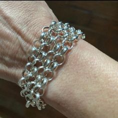 a person's hand with a chain bracelet on it