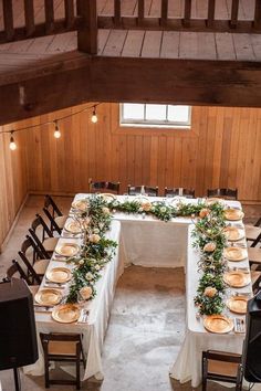 an overhead view of a long table with plates and place settings